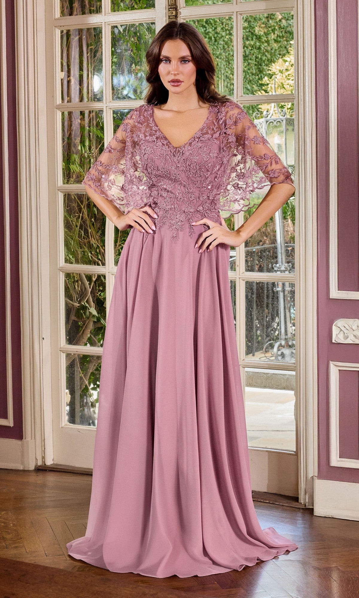 A woman poses gracefully indoors in the Ladivine CL10 long formal dress, featuring a dusty mauve hue with a lace-embroidered bodice and chiffon skirt, standing before glass doors.